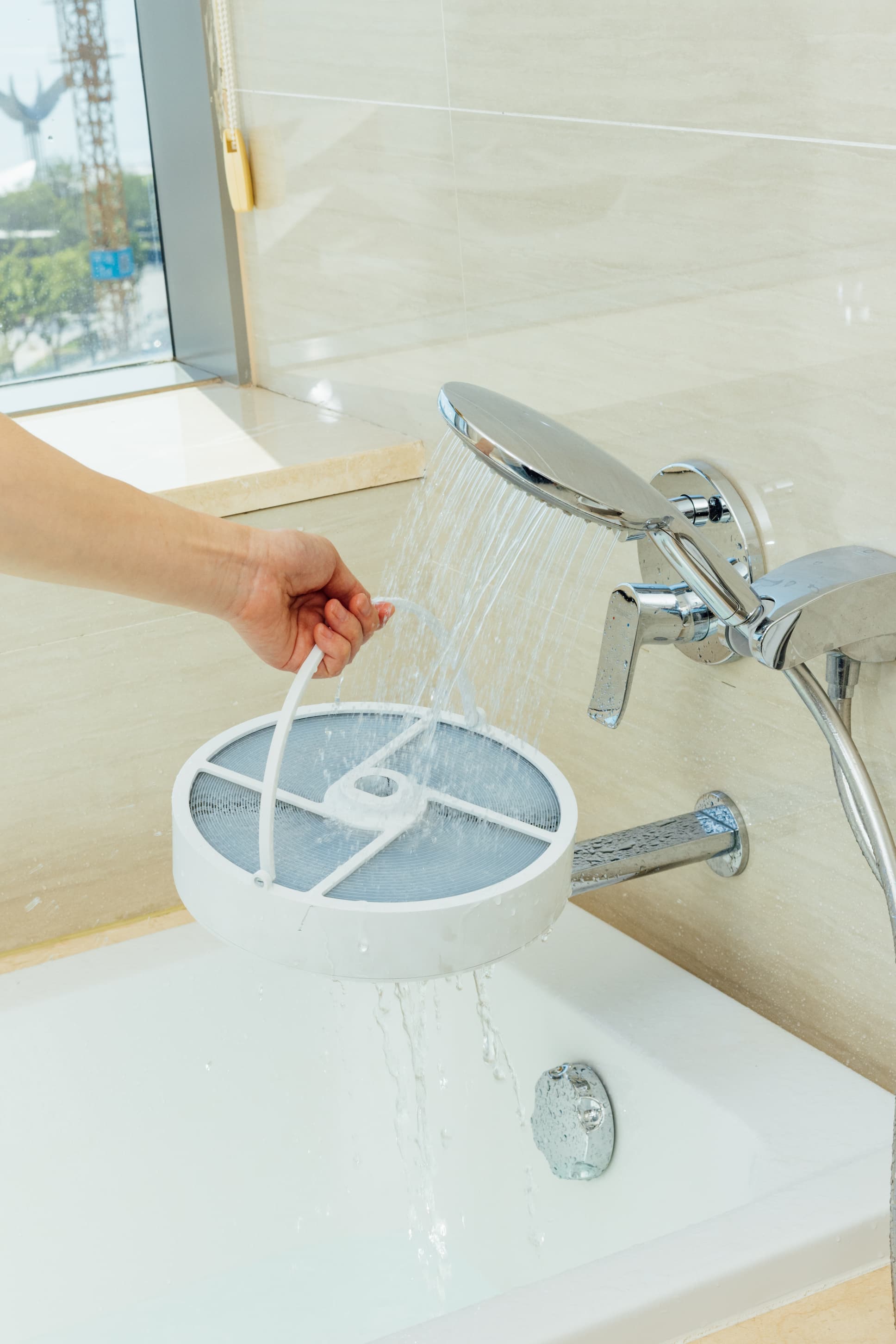 Person washing the filter of P50 Air Purifier in bathtub
