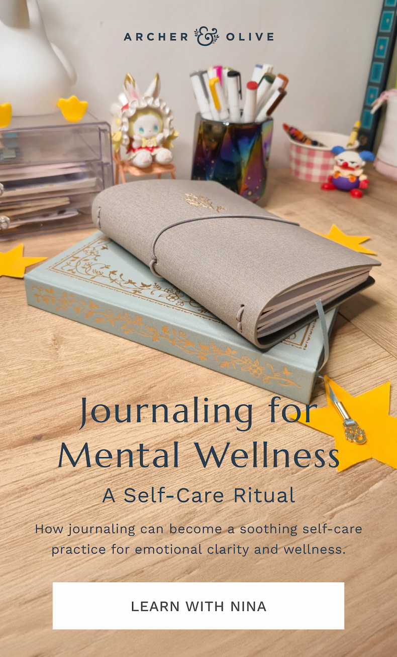 Two notebooks stacked with stationery in the background
