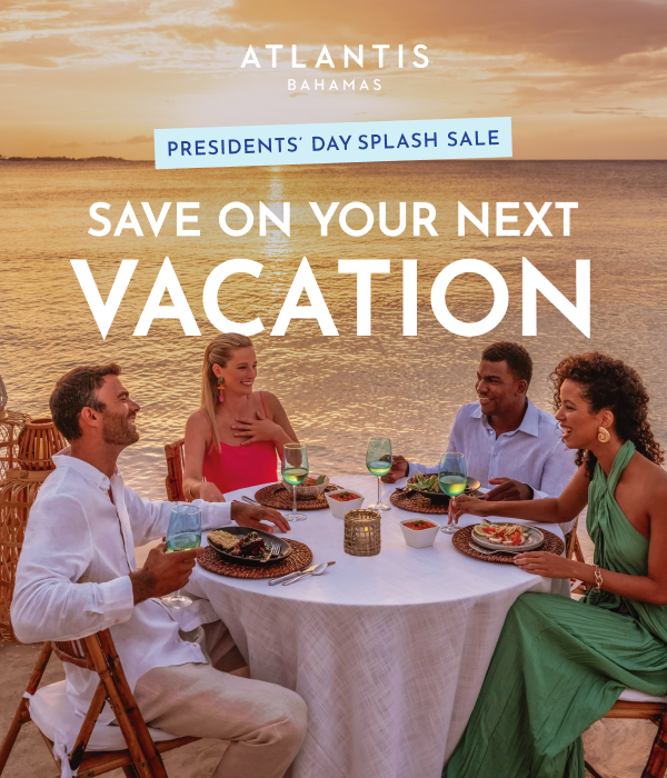 Group of people dining in front of a orange sunset at Atlantis