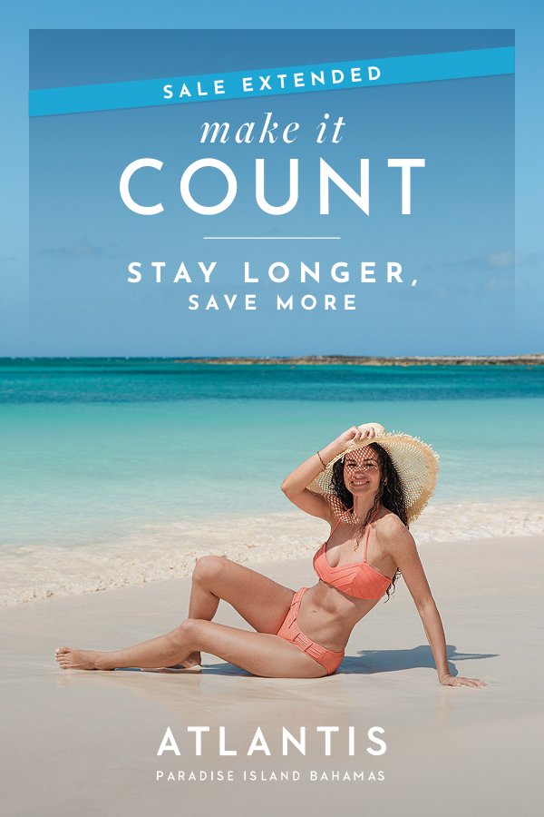 Make It Count: Final chance, every 3rd night free at Atlantis Bahamas. | A woman in a bikini joyfully posing on a white sand beach by the ocean.