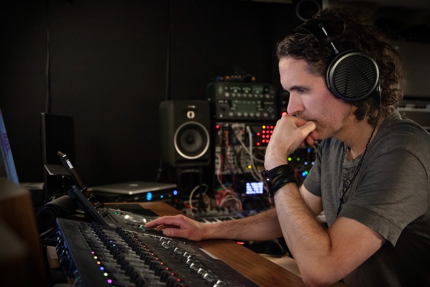 Artist working on a mixing board in studio