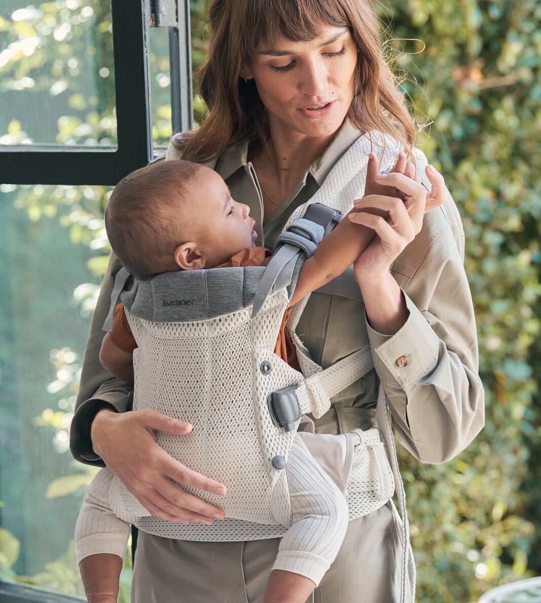 woman holding baby in carrier 