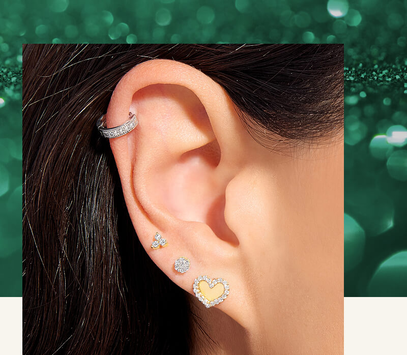 A woman poses, showcasing a variety of beautiful Gold & Diamond Earrings