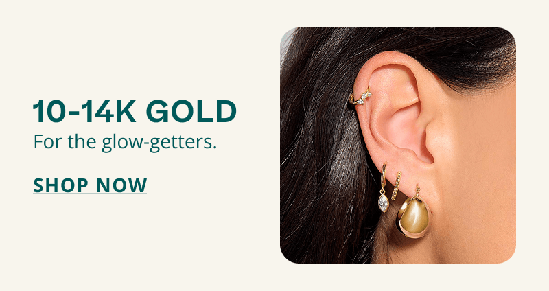 Model’s ear wearing array of gold hoops and huggies.  10-14K gold. For glow-getters. Click here to shop now.