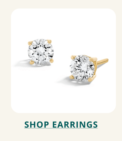 A pair of classic round-cut diamond stud earrings set in yellow gold. Click here to shop earrings