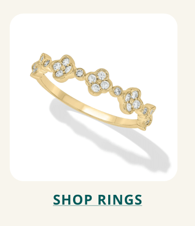 A yellow gold band featuring a repeating floral pattern pavé-set with stones. Click here to shop rings