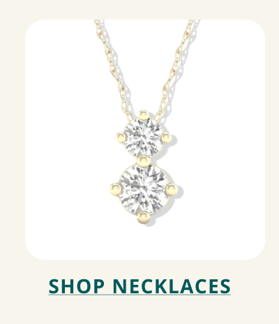 A yellow gold pendant necklace with two vertically stacked, round-cu stones. Click here to shop necklaces