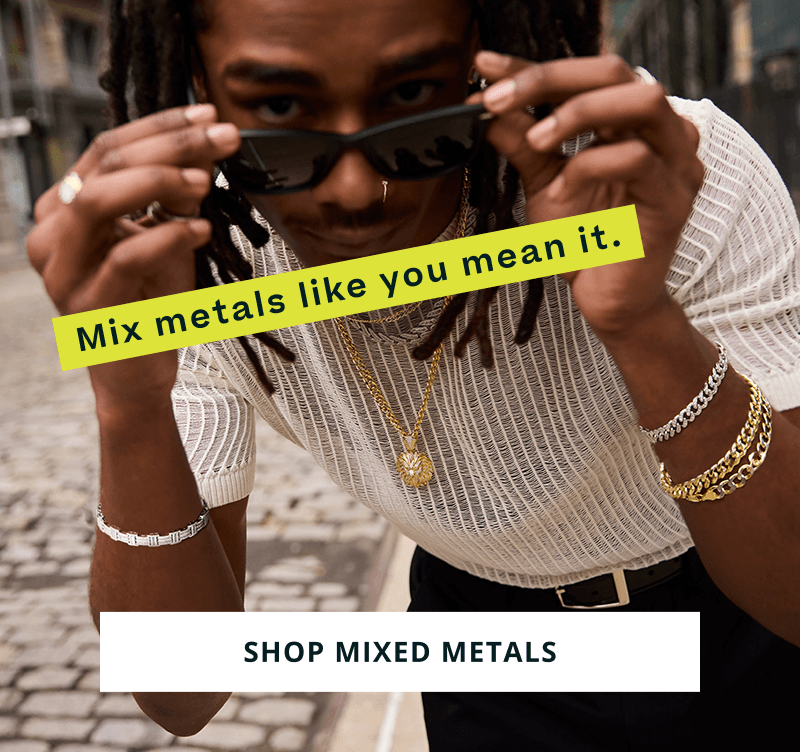Male in sunglasses, wearing thick gold & silver chain bracelets, rings & necklaces. Mix metals like you mean it. Click here to shop mixed metals