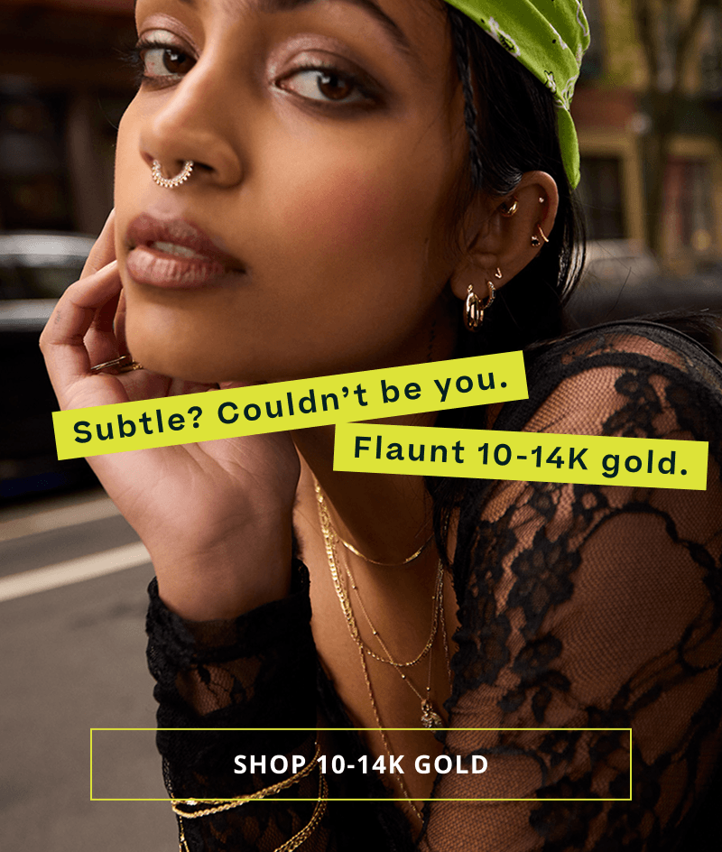 Model with statement gold chains, pendants, earrings & septum ring. Subtle? Not you in gold. Click here to shop 10-14K gold