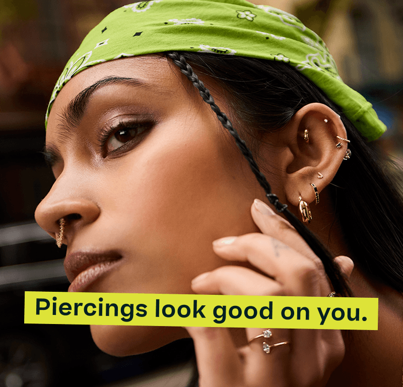 Model with statement gold, diamond & gemstone geometrical ear stack, rings & septum ring. Piercings look good on you.