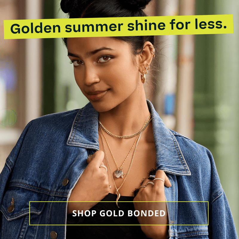 Model wearing bold gold chains with thick pendants, hoops & diamond encrusted rings. Golden summer shine for less. Click here to shop gold bonded