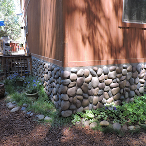 Faux river rock wall panels seen in exterior wainscoting of home 