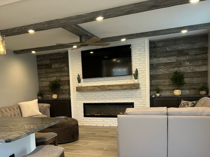 Skip bedell living room project with barron designs wall panels, mantle and wood beams