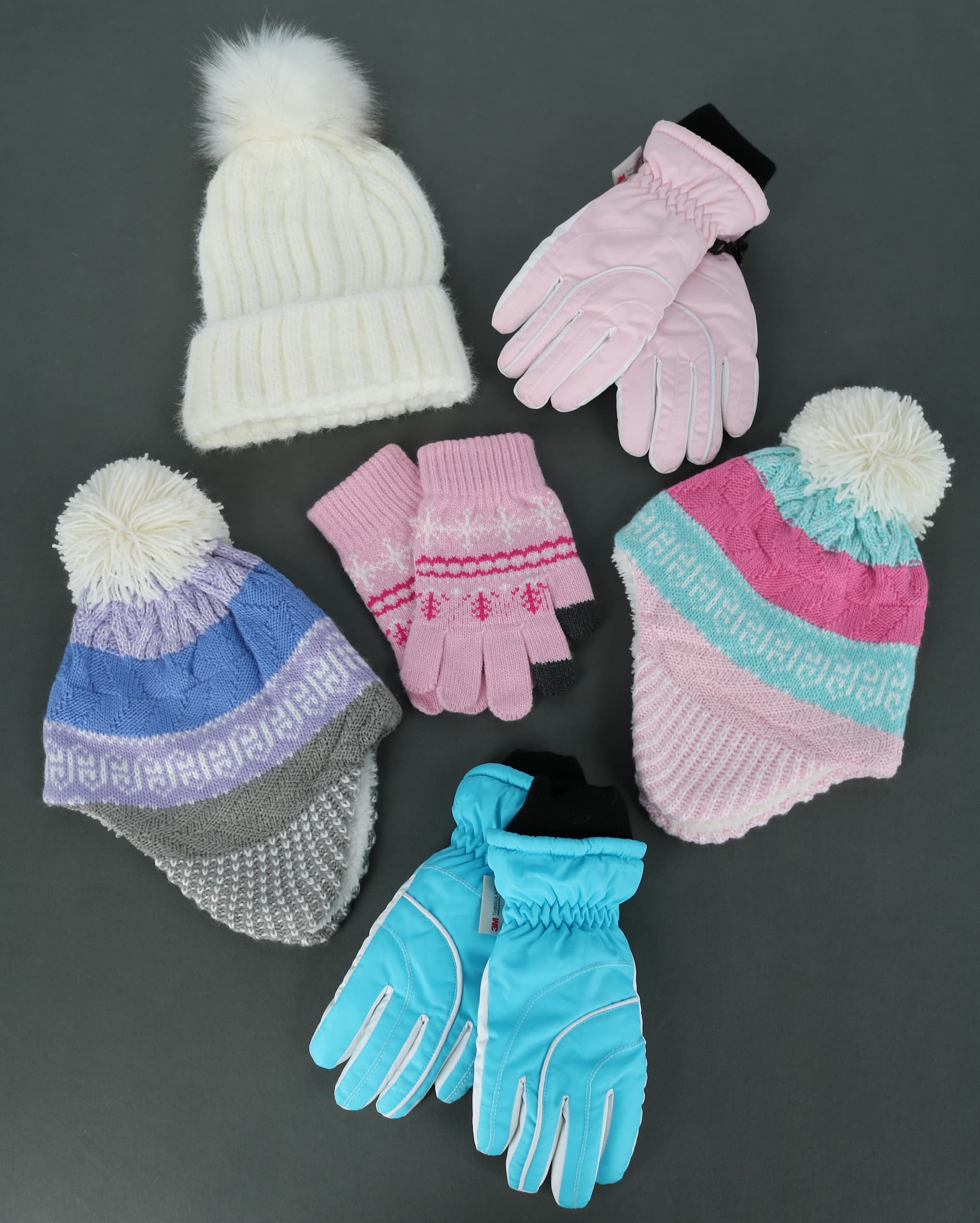 Winter hats and gloves in pink, blue, and white