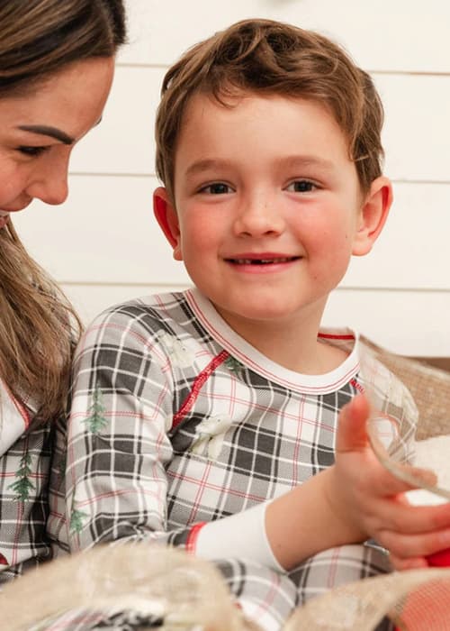 Mom holding son on her lap wearing matching pajamas