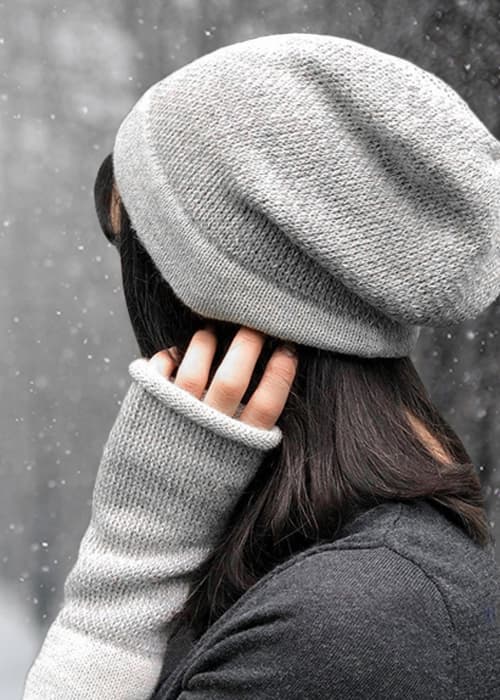 Woman wearing hat and arm warmers in snow