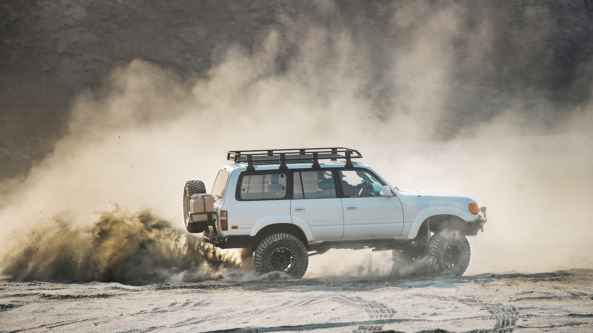 Vehicle driving on dirt with a lot of dust in the air