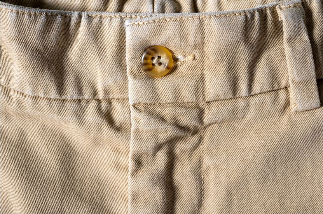A photo of khaki colored Bills Khakis Heritage Wash front button and belt loop area
