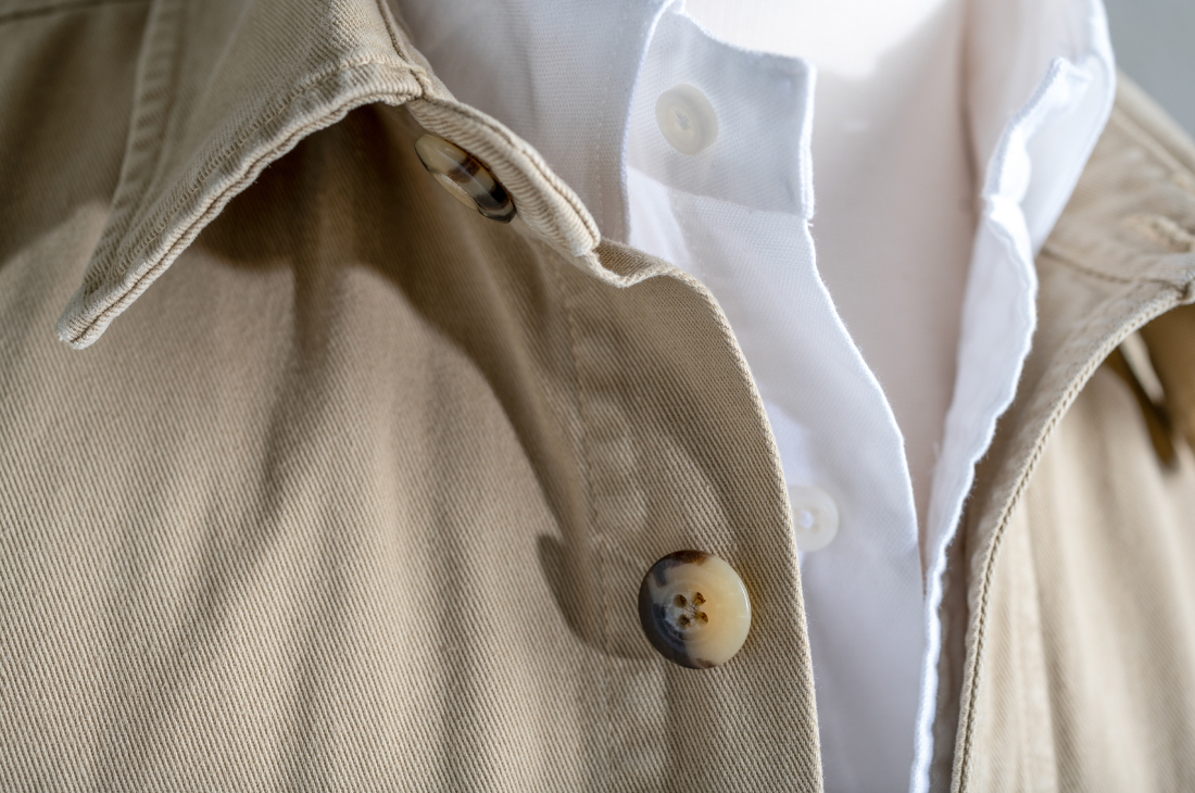 A collar detail of a khaki colored Bills Khaki's overshirt over a white Bills Khakis standard fit shirting.