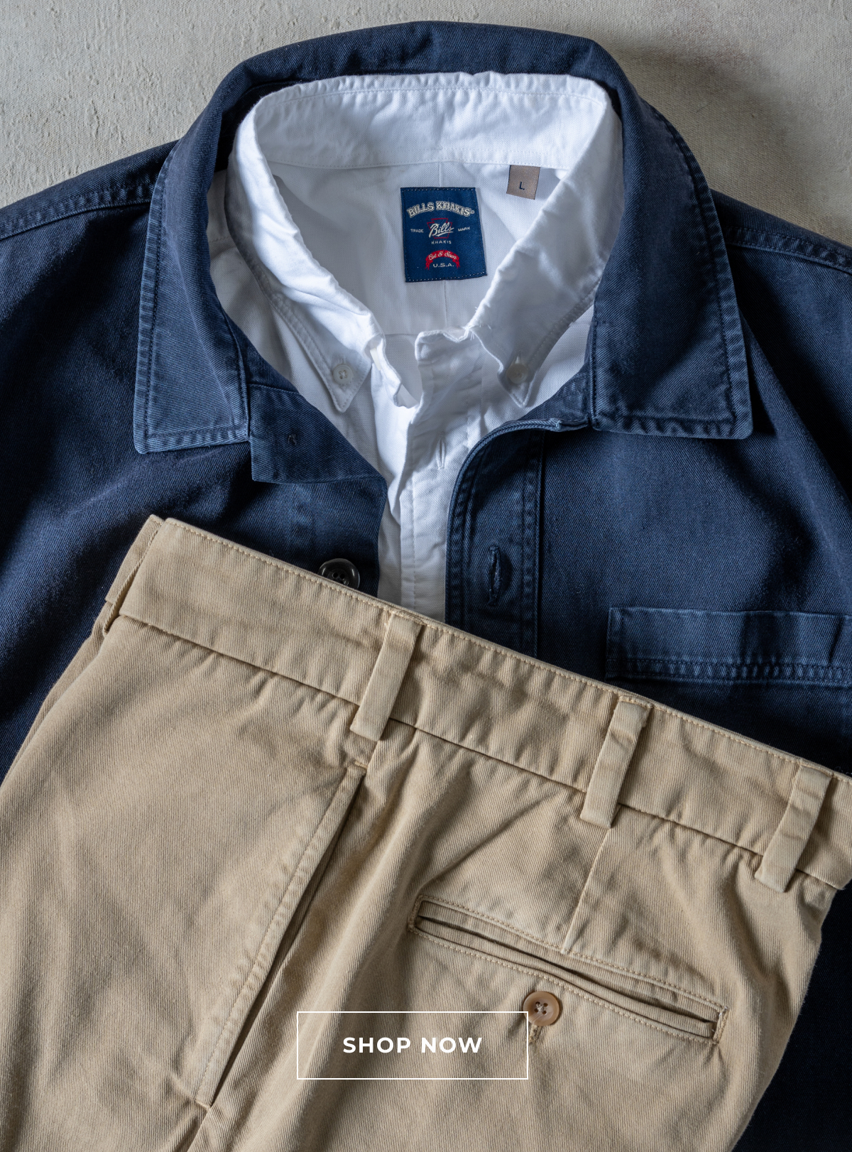 A laydown of the same Bills Khaki navy overshirt, white standard fit shirt, and khaki pants. A button reads Shop Now