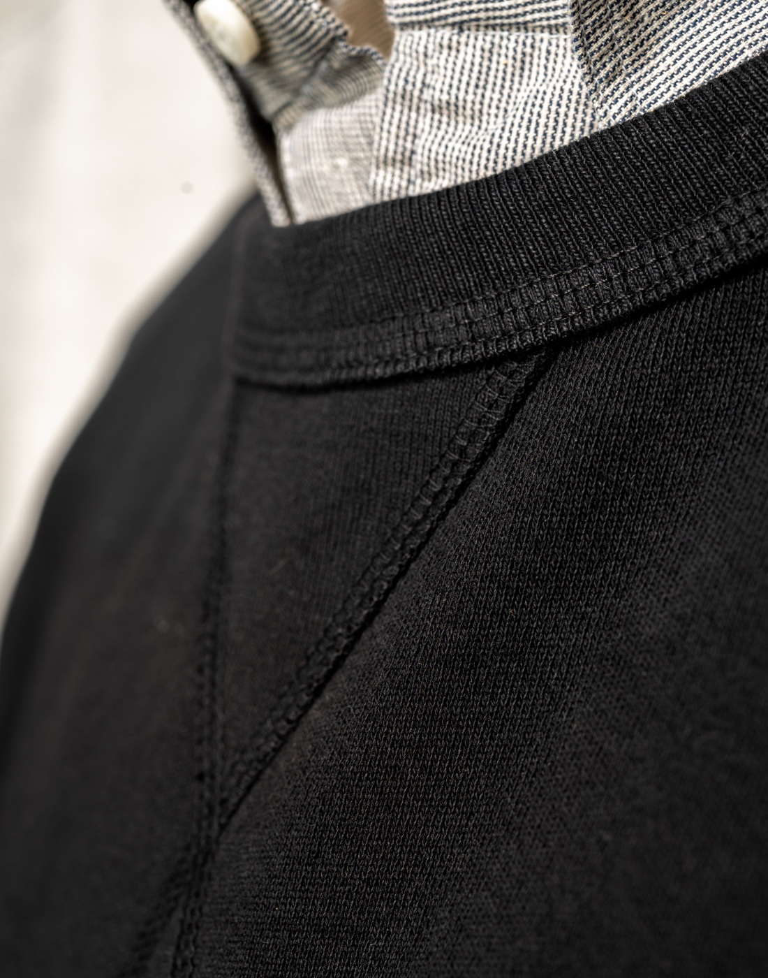 A close up of the collar stitching of black Bills Khakis lightweight sweatshirt