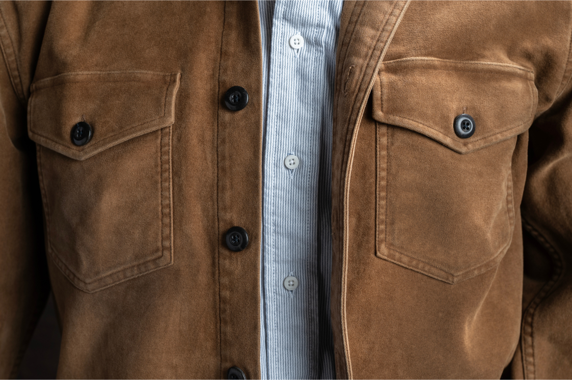 A detail of the chest area of a light brown Bills khaki overshirt over a standard fit shirt