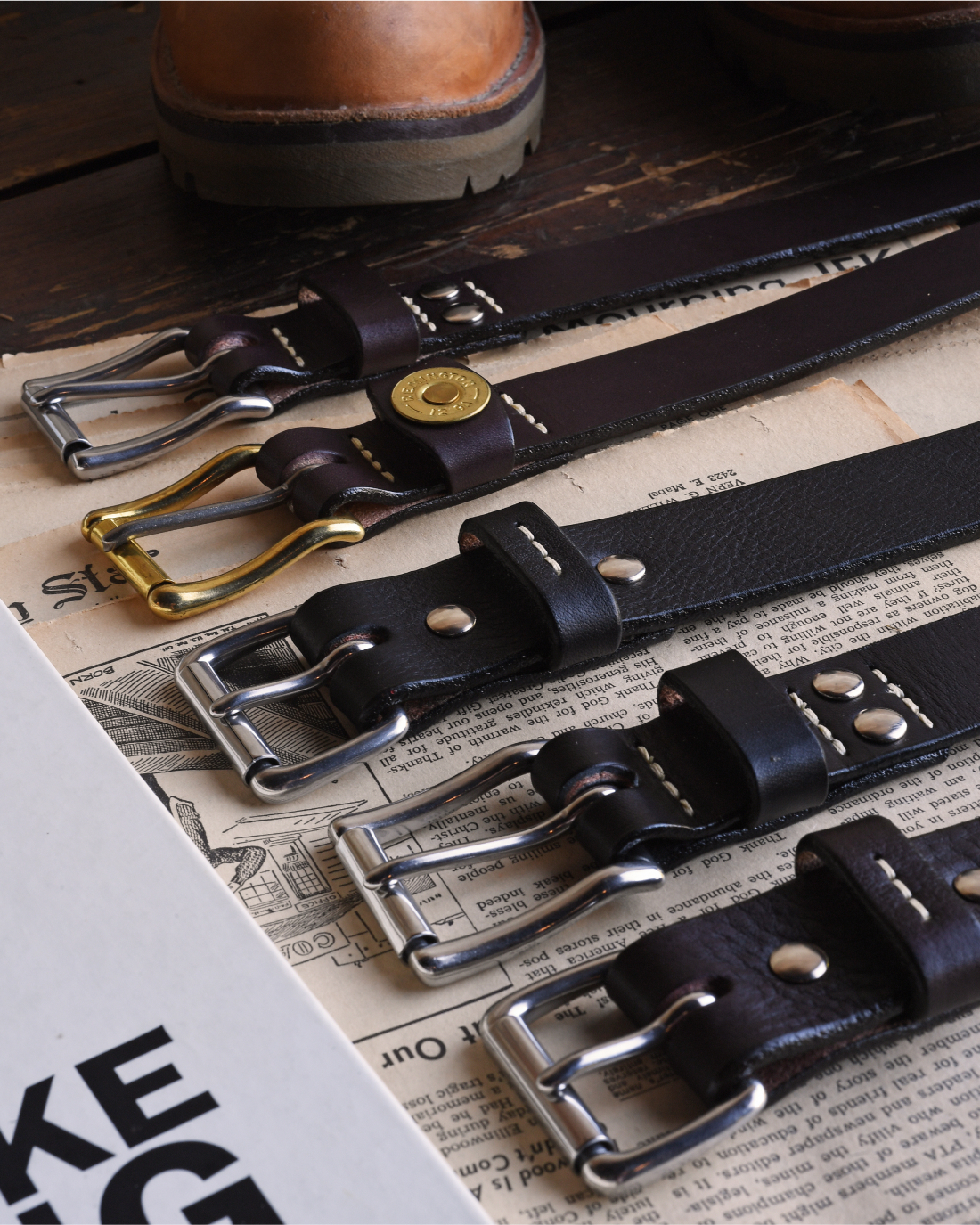 An array of Bills Khakis leather belts laid across a vintage surface