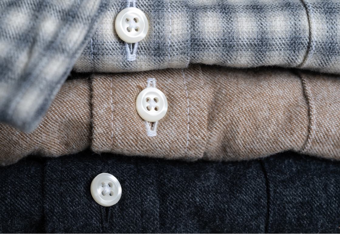 A closeup of three folded Bills Khaki brushed flannel shirts