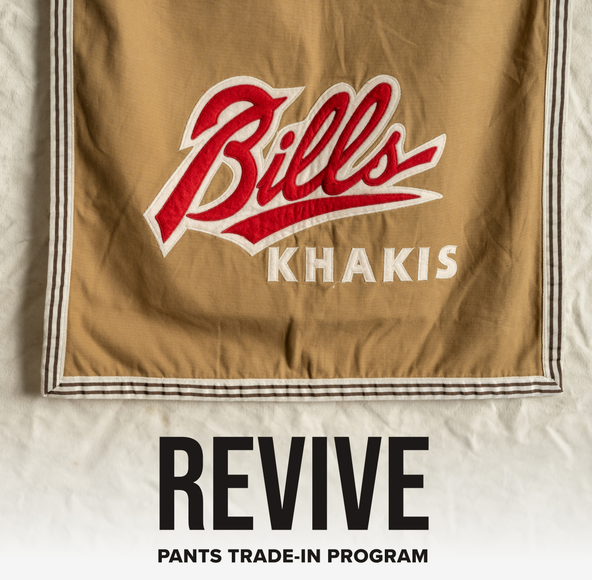 Revive Logo | Pants Trade-In Program logo ontop of an image of vintage Bills Khakis flag.