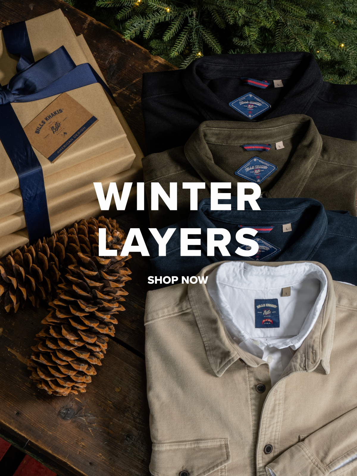Four Bills Khakis overshirts folded on a dark walnut sruface with christmas presents, pine, and pinecones cropped alonge the borders