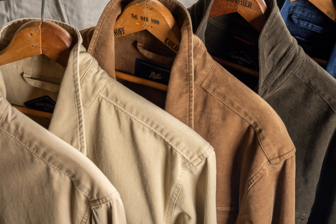 An Array of Bills Khakis overshirts hang from hangers