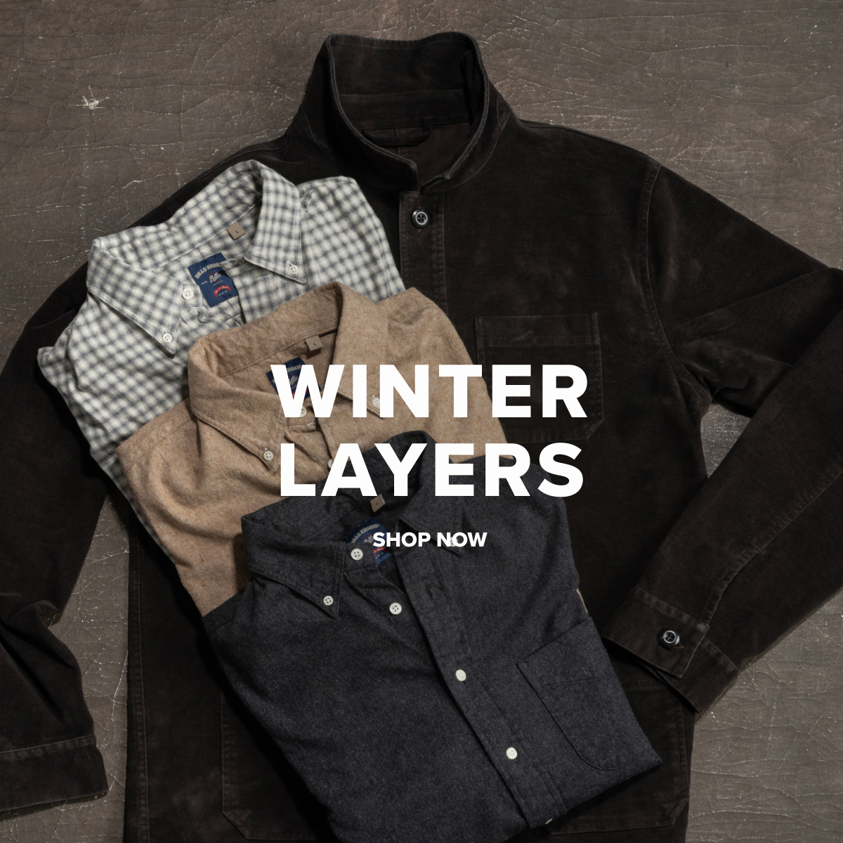 A Bills Khakis Washed Moleskin Chore Jacket lays on an industrial brown surface with multiple Bills Khakis Flannel Shirts