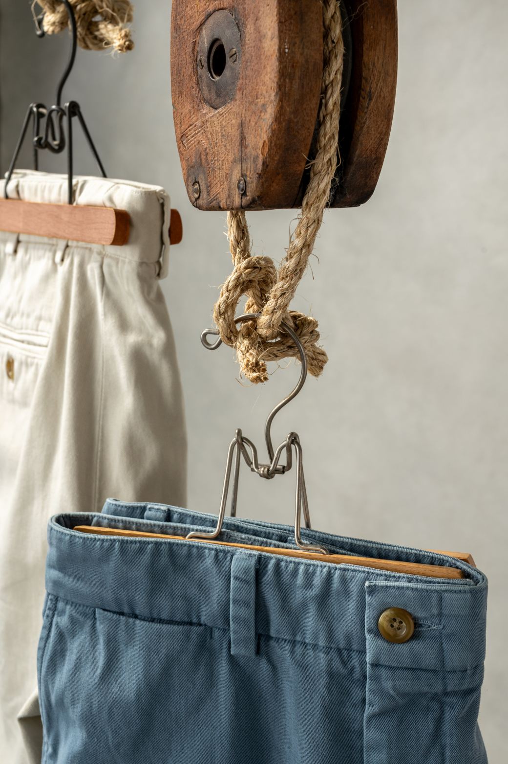 Two pairs of heritage wash pants hang amongst vintage shipyard pulleys