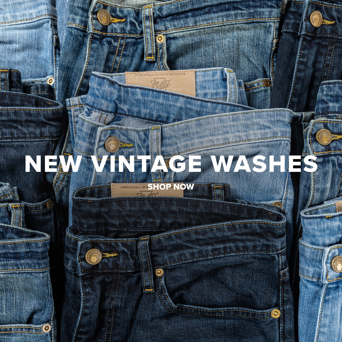 An array of colors of folded Bills Khakis new Vintage Wash Denim pants. Copy on the photo reads: New Vintage Washed | Shop Now