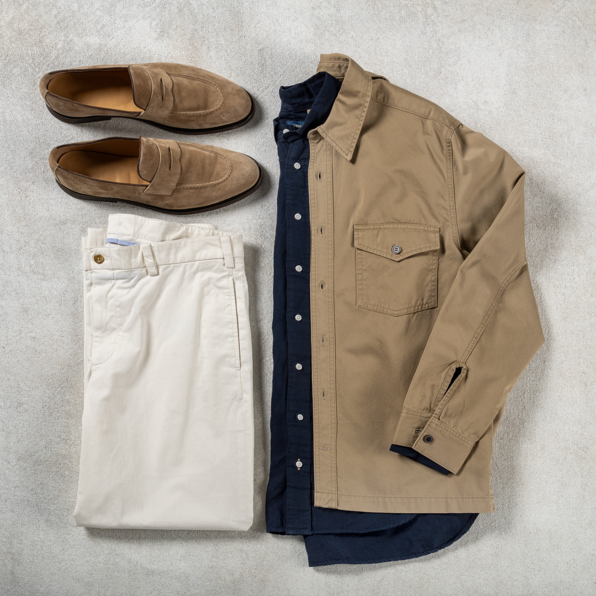 A Bills Khakis Broken-In Twill Overshirt alongside standard fit shirt, khaki pants and loafers
