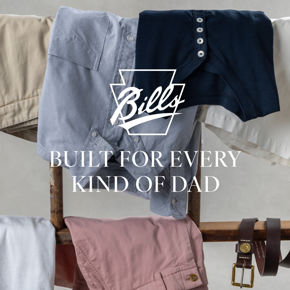 Bills Khakis shirts, shorts, henleys and belts lay relaxed on wooden polls. Text overlay has the Bills Khakis logo along with text 'Built for Every Kind of Dad'