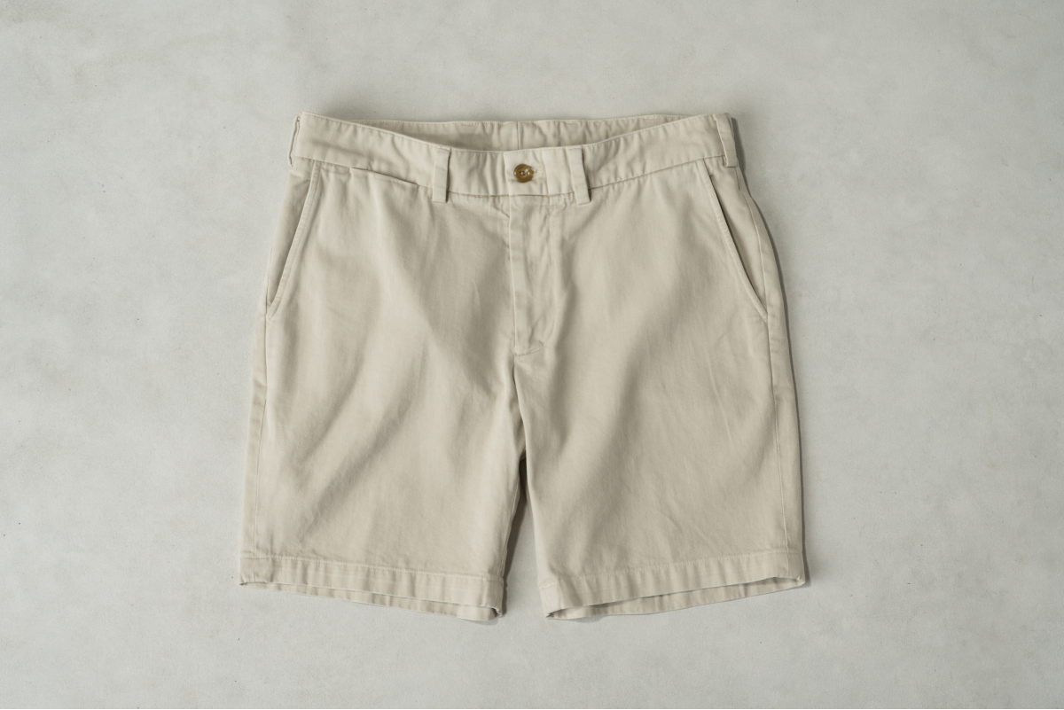 A pair of khaki colored Bills Khakis shorts lay on a light colored surface