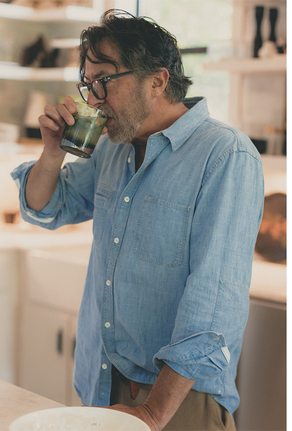 Billy wears the Chambray Field shirt while sipping a cocktail.