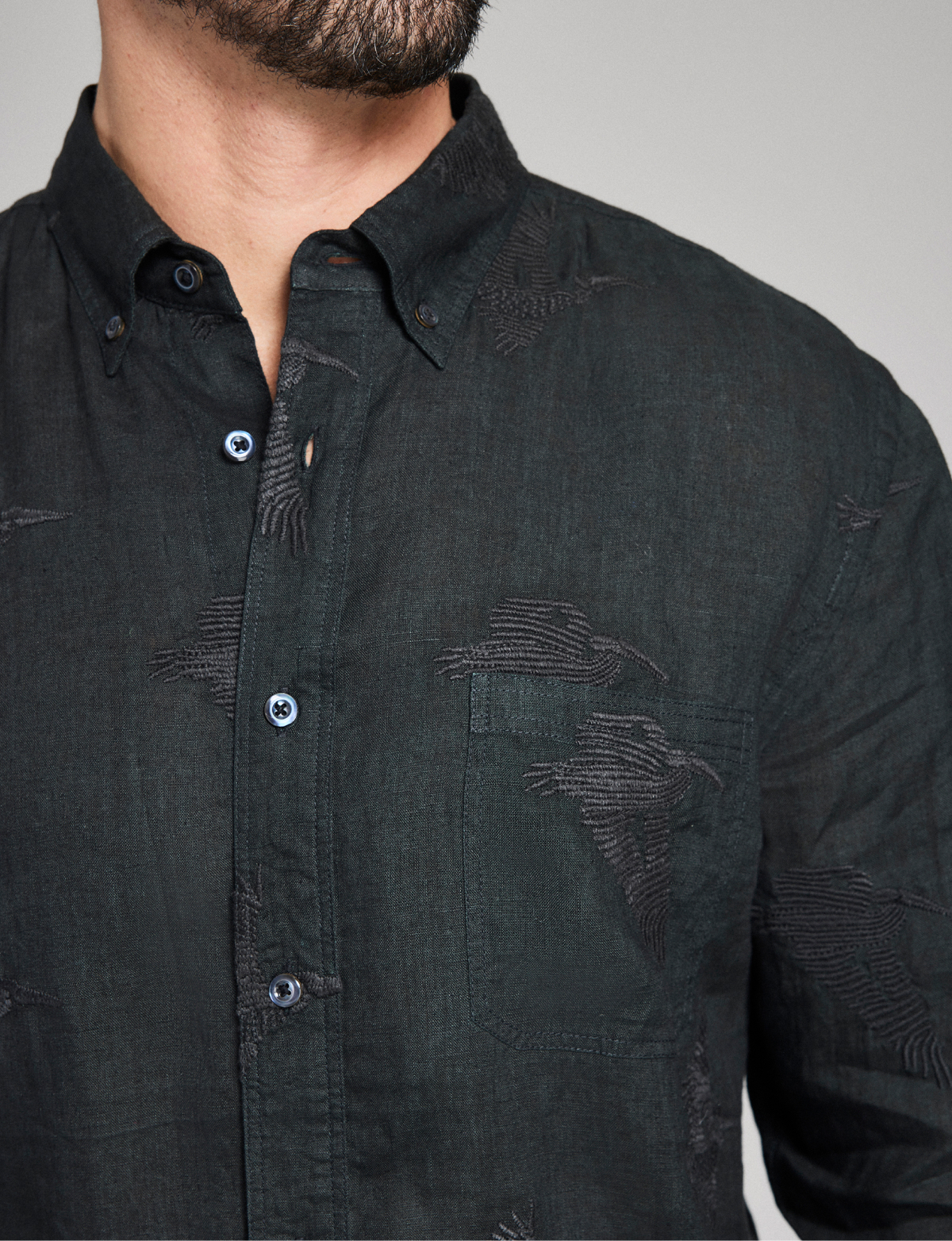 Model wears a black embroidered Billy Reid button down shirt.