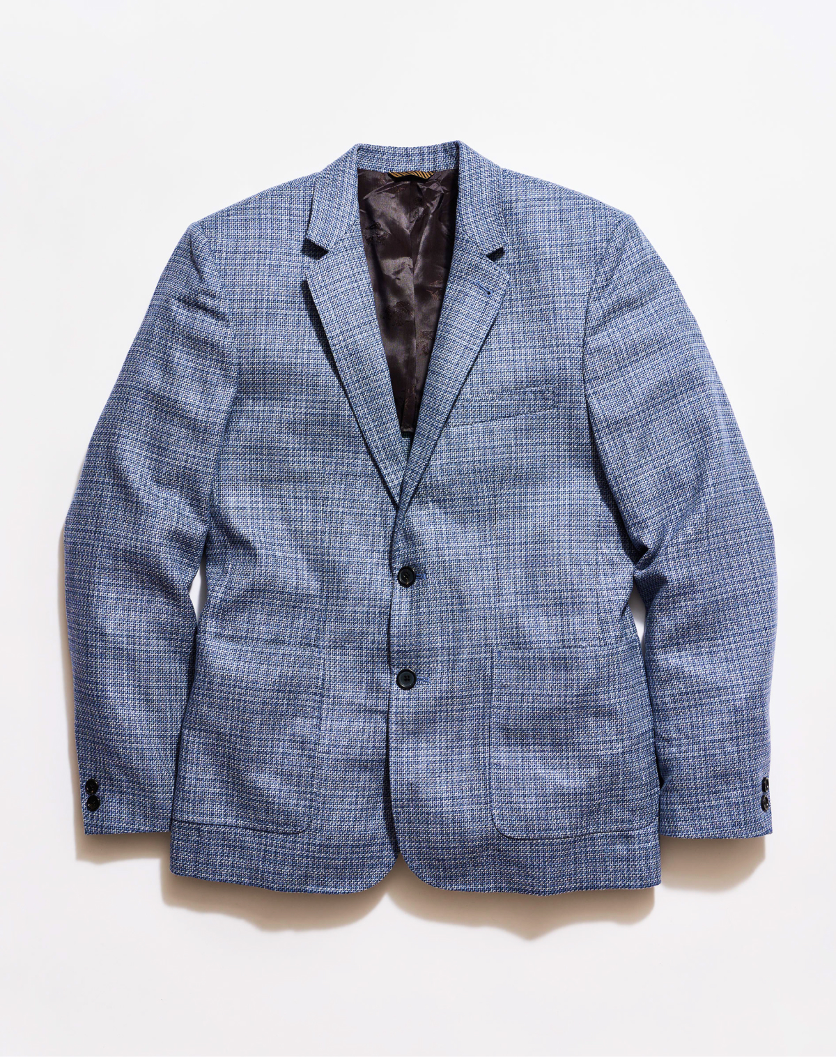A blue plaid sport coat on a grey background.