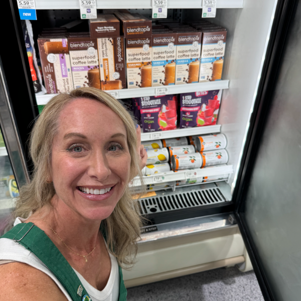 Tiffany Taylor, Founder of Blendtopia, next to all three blendtopia superfood lattes in the freezer section at publix