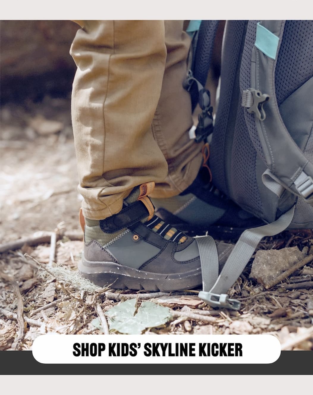 Closeup of a kid next to his backpack wearing his Skyline Kicker shoes