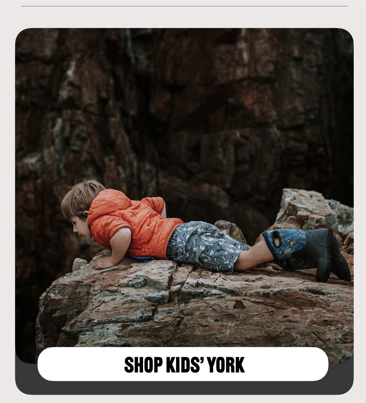 A kid looking over a cliff edge.