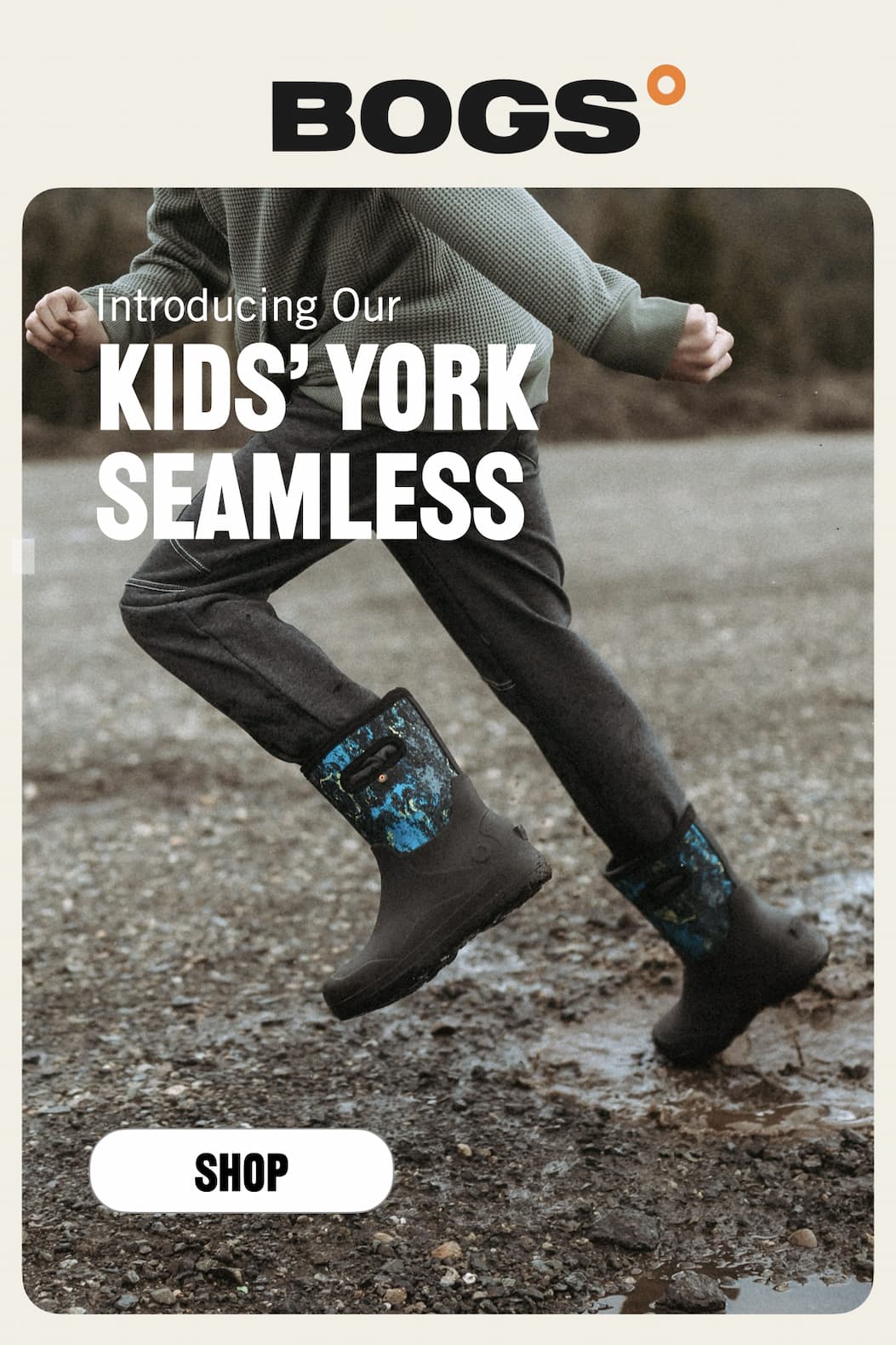 A closeup of a kid running through a muddy puddle.