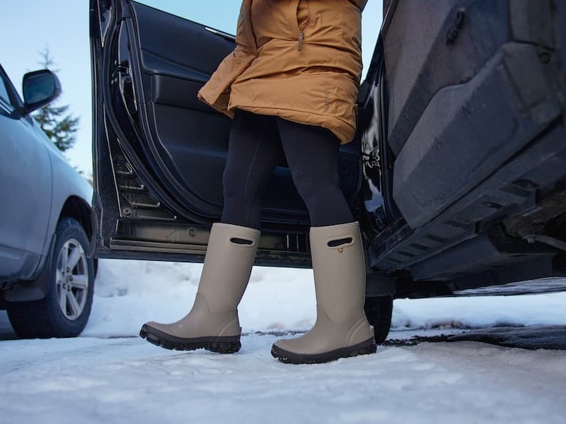 A woman getting out of her car wearing the whiteout dots winter boots in white/tan.
