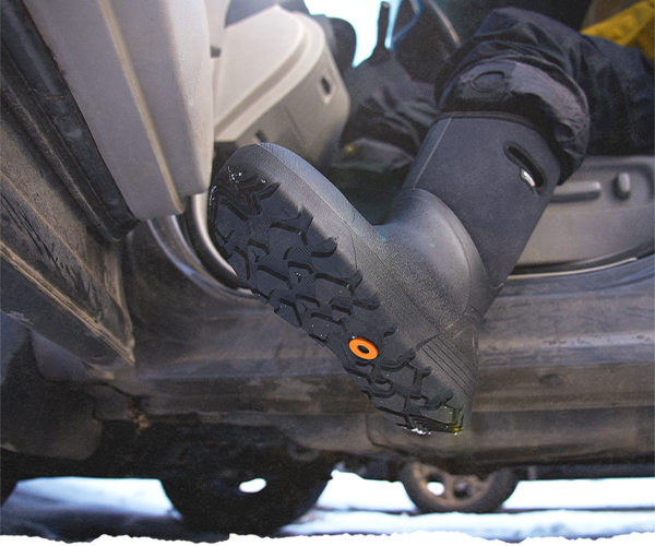 A guy exiting his car wearing the Bozeman Tall winter boots