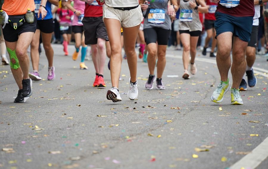 marathon runners’ legs and feet hitting pavement
