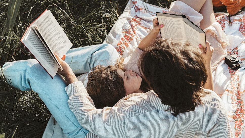 couple reading on a picnic blanket