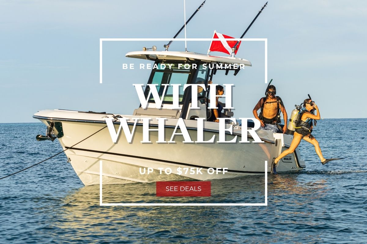 Two scuba divers prepare to enter the water from a Boston Whaler boat. Text reads, "Be Ready for Summer with Whaler. Up to $75k off. See Deals."