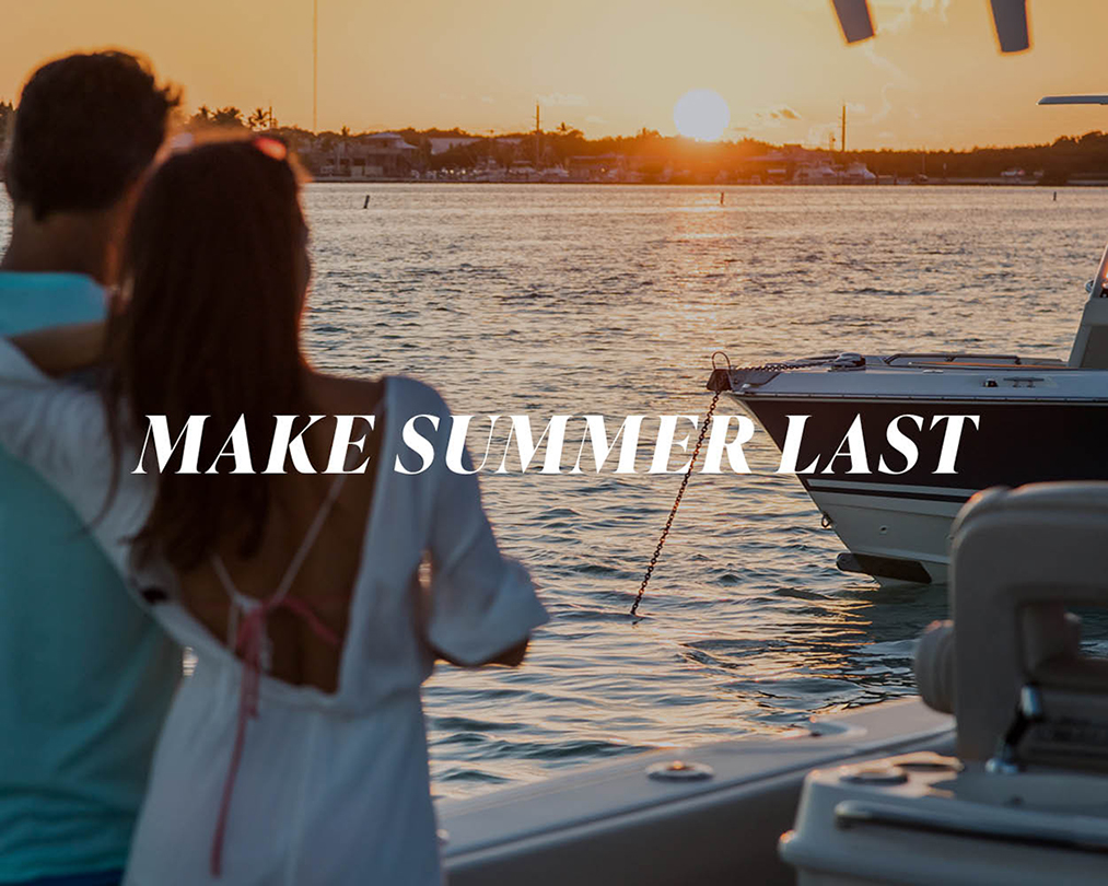 "Make Summer Last" text overlay on a picture of two people on a boat watching the sunset.